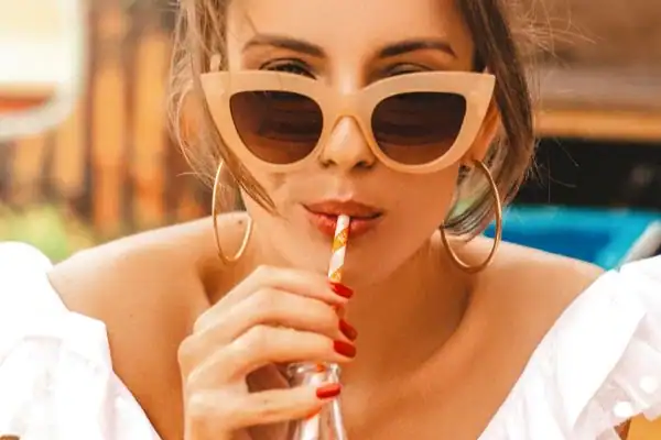 woman drinking from straw as part of teeth whitening aftercare Andover